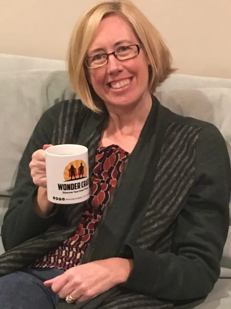 A woman sitting on the couch holding a mug.