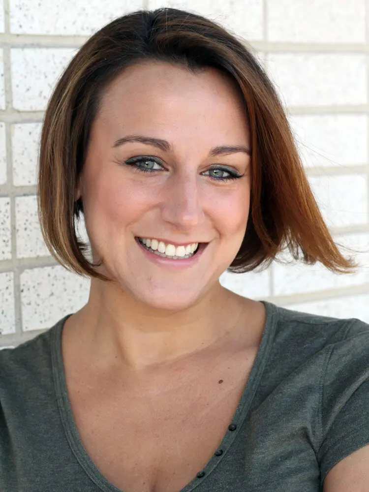 A woman with short hair smiles for the camera.